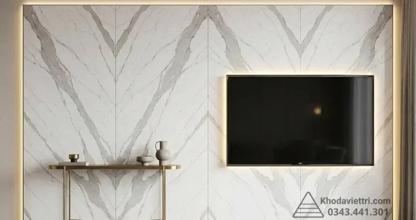 Vách tivi phòng khách ốp đá thạch anh quartz ghép vân đối xứng bookmatch hình mũi tên chuẩn phong thủy.